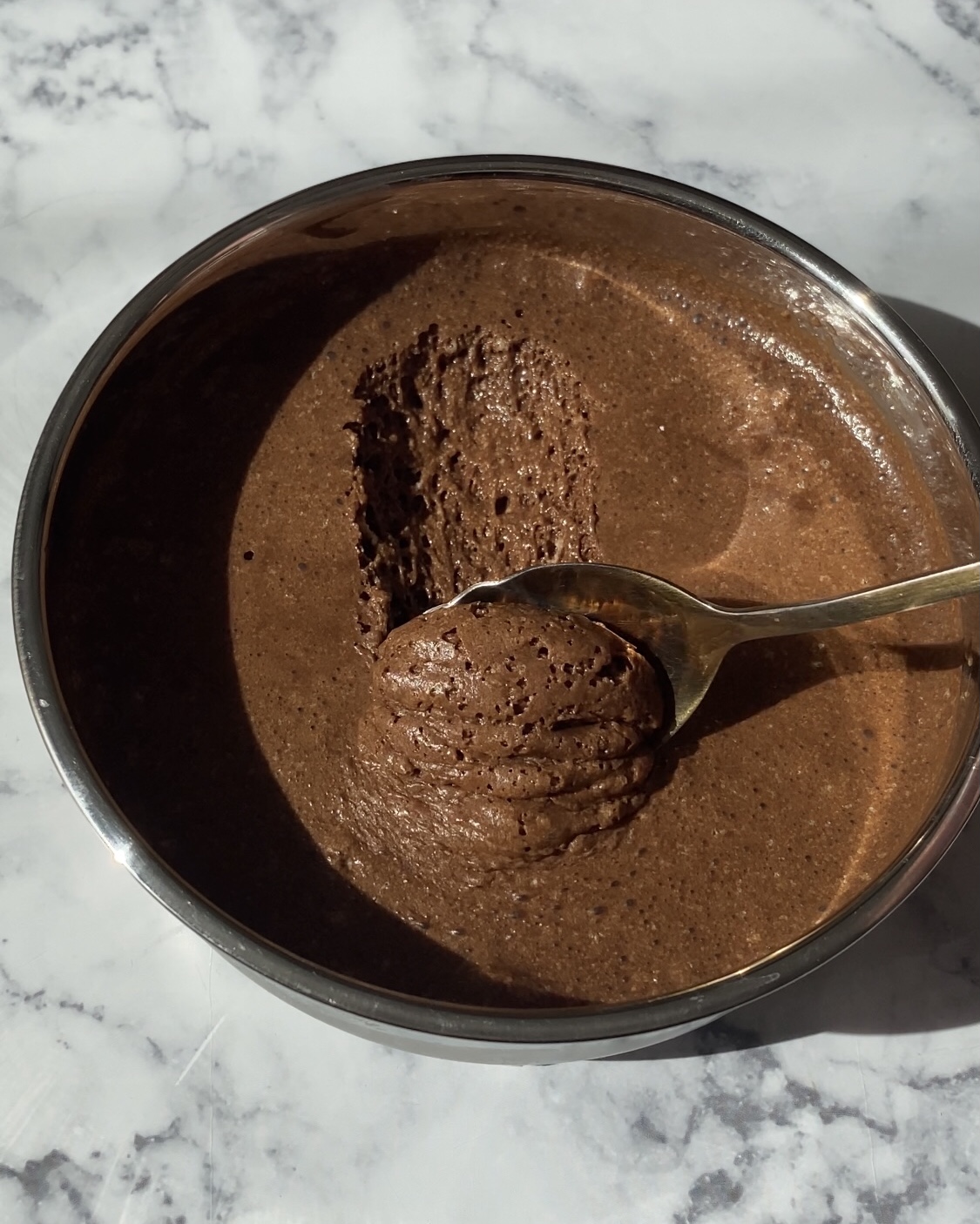 Mousse au chocolat noir faite maison, dans un plat en inox