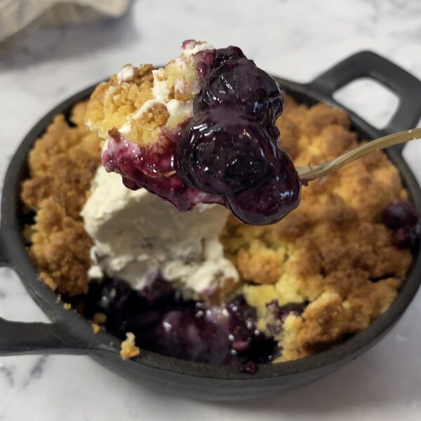 Crumble sans gluten aux myrtilles dans un plat à four en fonte rond