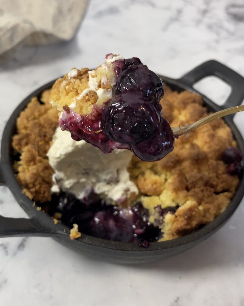 Crumble sans gluten aux myrtilles dans un plat à four en fonte rond