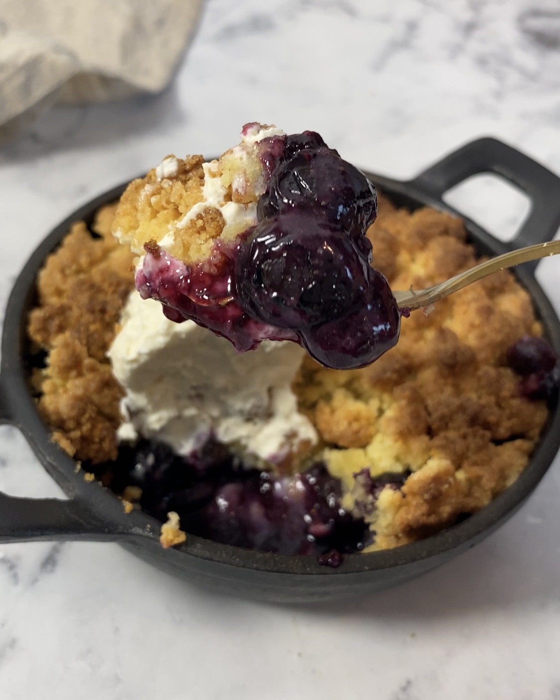 Crumble sans gluten aux myrtilles dans un plat à four en fonte rond