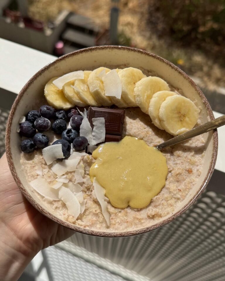 Porridge sans gluten de sarrasin au chocolat, dans un bol avec des toppings de myrtilles, banane et noix de coco