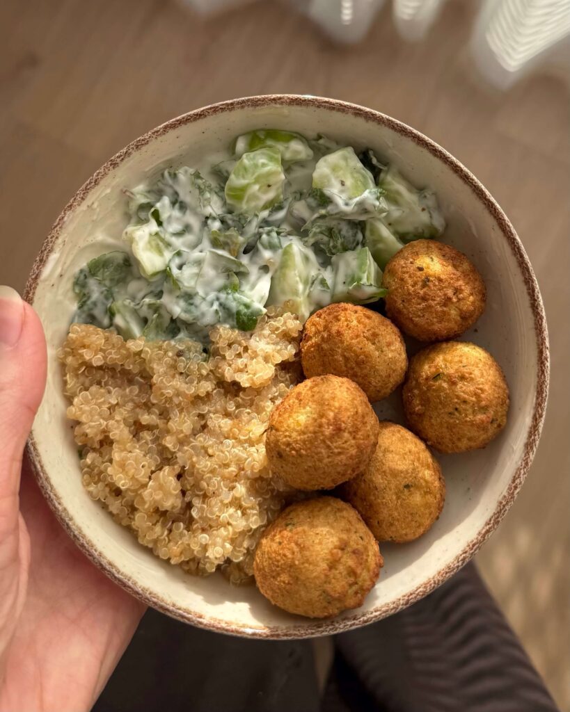 Boulettes de légumes style falafel servies dans un bol avec du quinoa et une salade de concombre